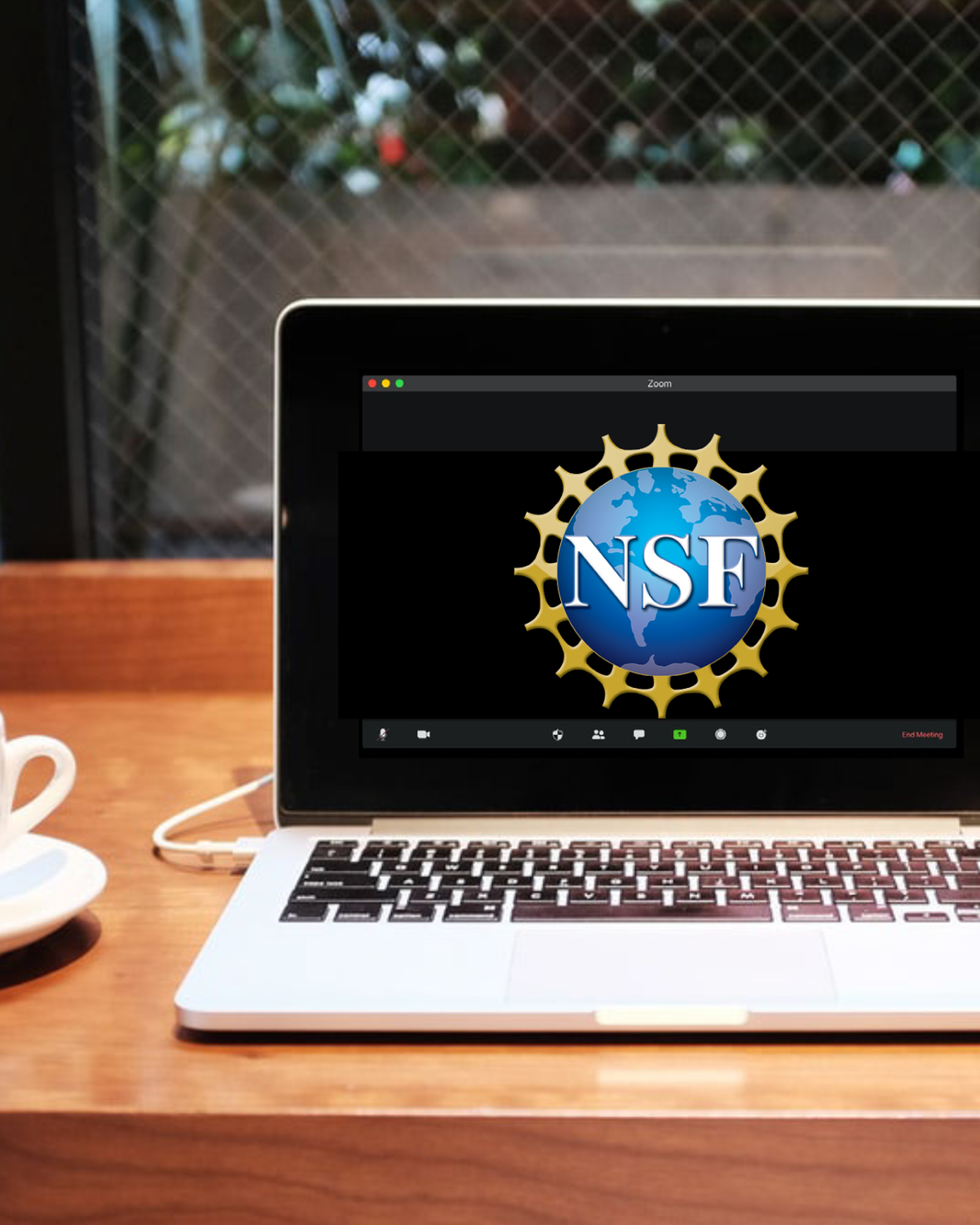 A photo of a cup of coffee and a computer showing the NSF logo.