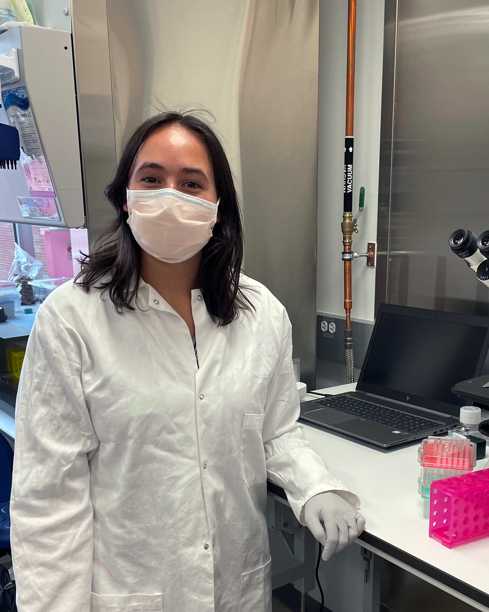 Sophie Vrba in the lab wearing a mask and lab coat