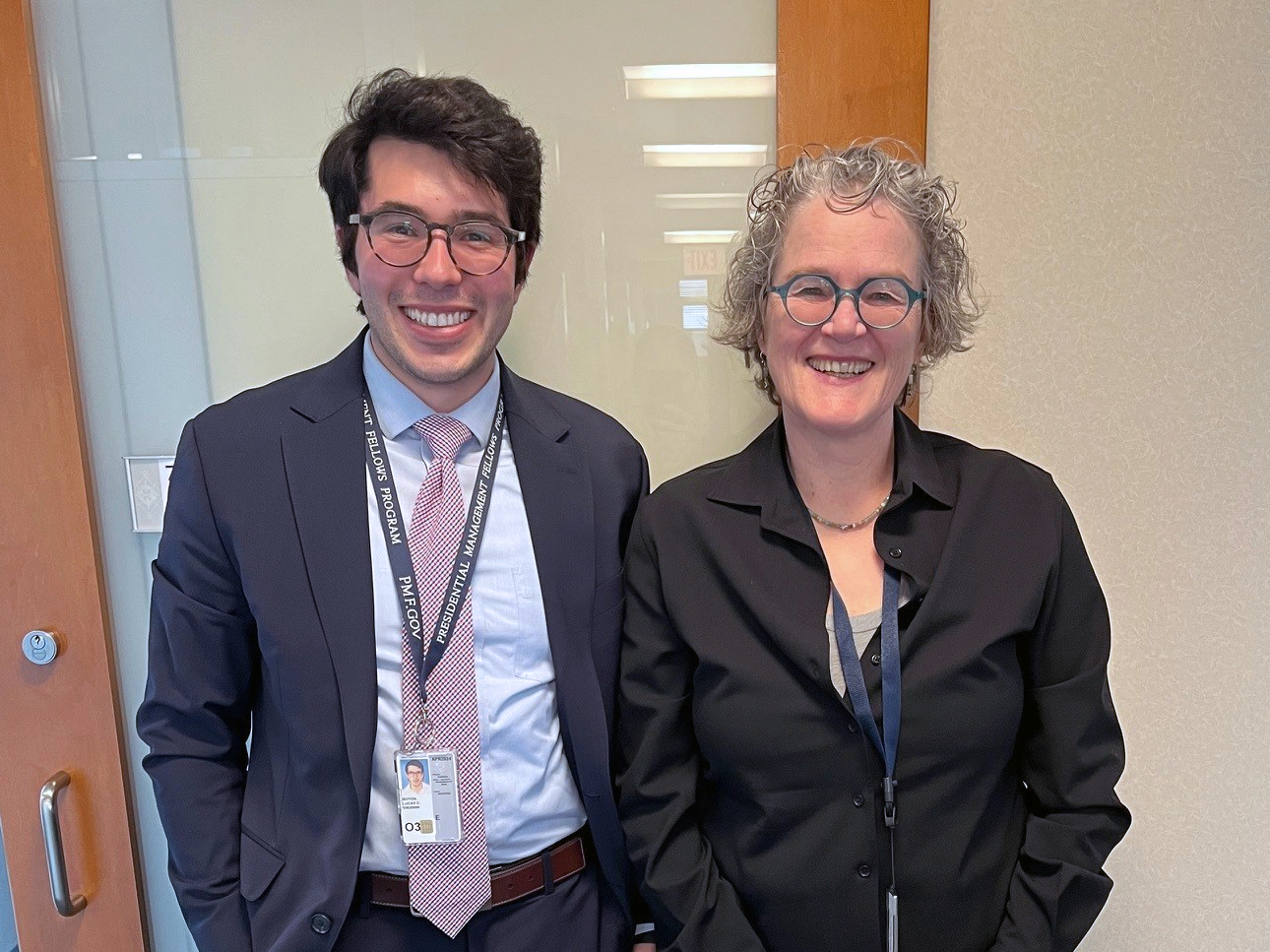 Two people in an office smiling for the photo.