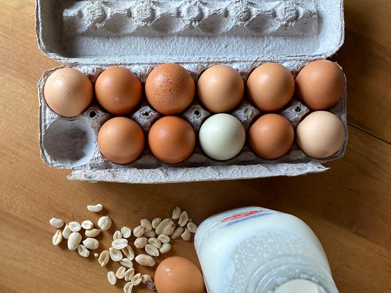 A photo of eggs, milk, and peanuts