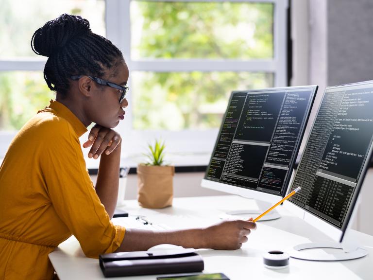 a person sitting at a desk working at a computer