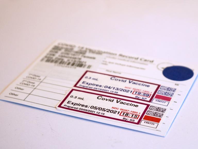 White card with black text recording two doses of COVID-19 vaccine.