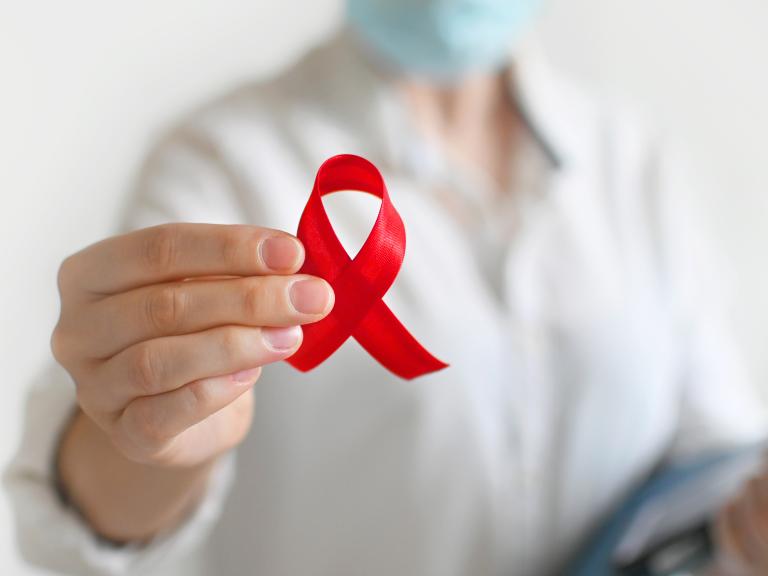 Doctor holding a red HIV ribbon