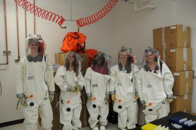 The image shows students trying on positive-pressure research suits in the BSL-4 training room at NIAID’s Rocky Mountain Laboratories.