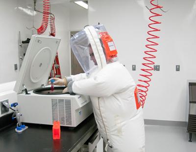 Virologist using a centrifuge inside a BSL-4 suite