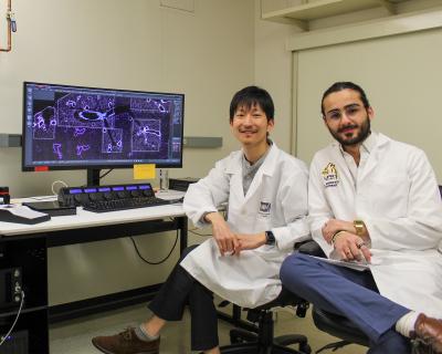 Armando Arroyo-Mejias and Hiroshi Ichise at desk with a computer.