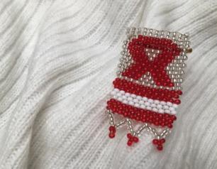 Beaded AIDS Awareness ribbon pin on knit scarf